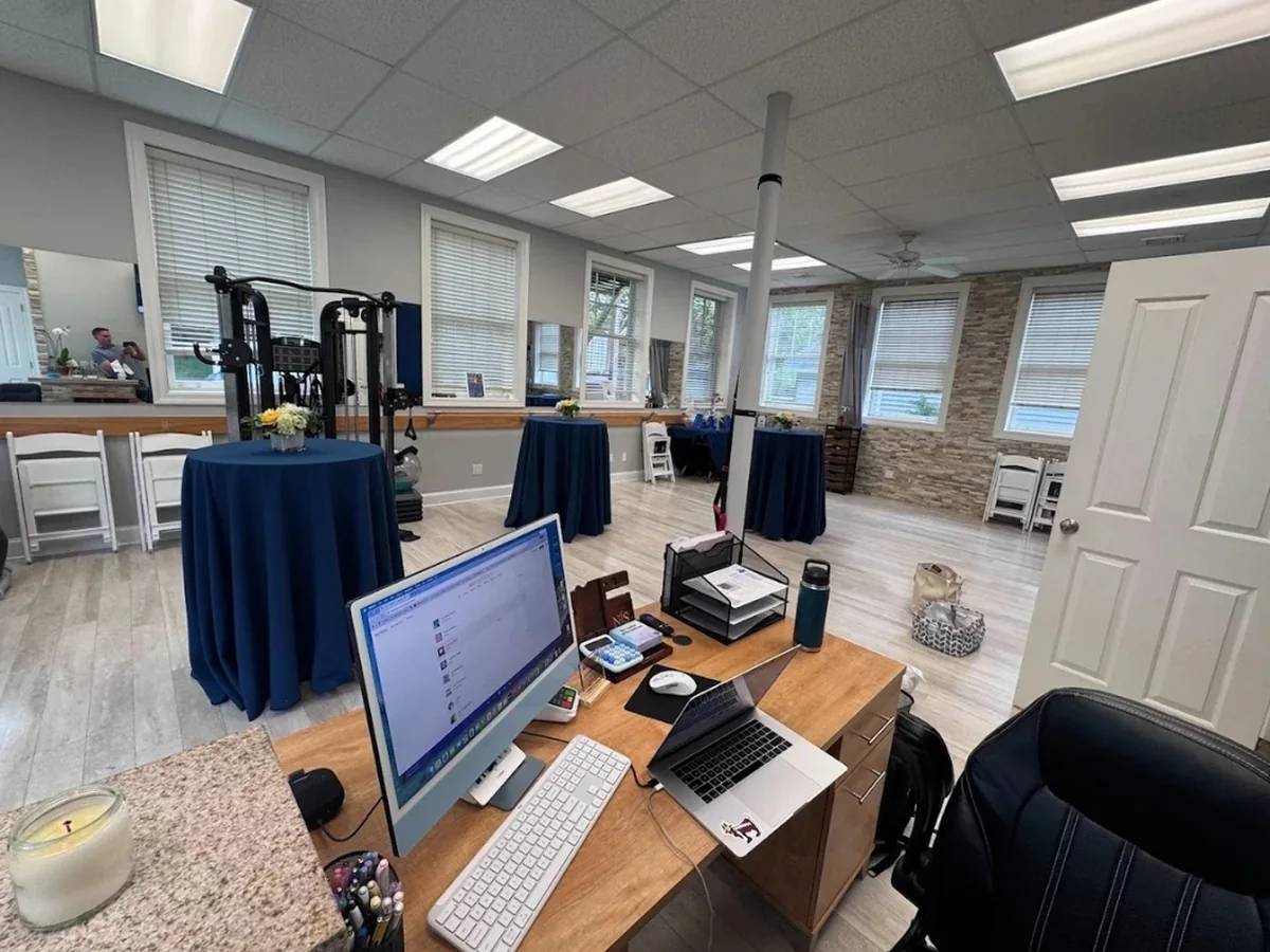The open treatment floor at the Quogue office, with windows on three sides and a functional trainer