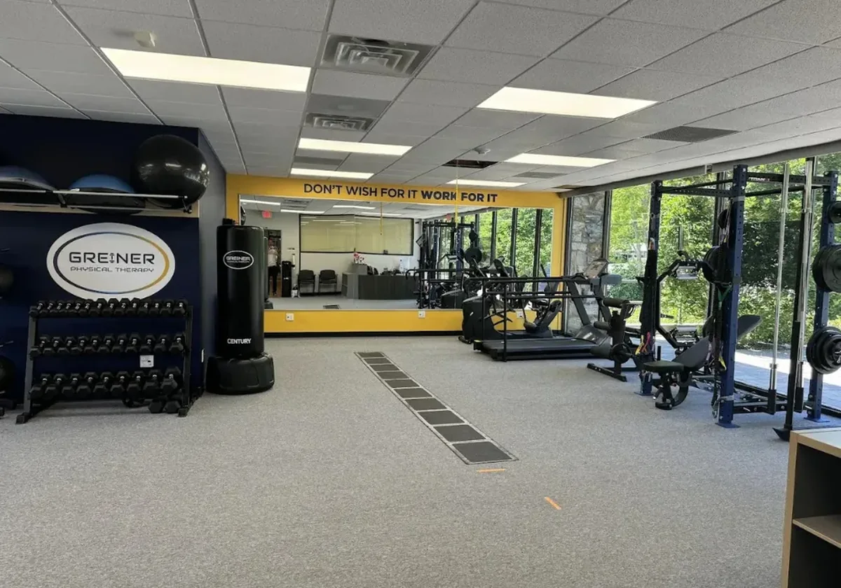 The open gym floor at the Speonk clinic with a dumbbell rack, heavy bag and cable equipment