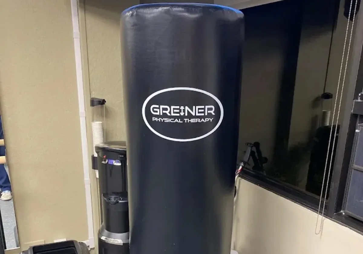 Punching bag in the foreground with the equipment wall behind it